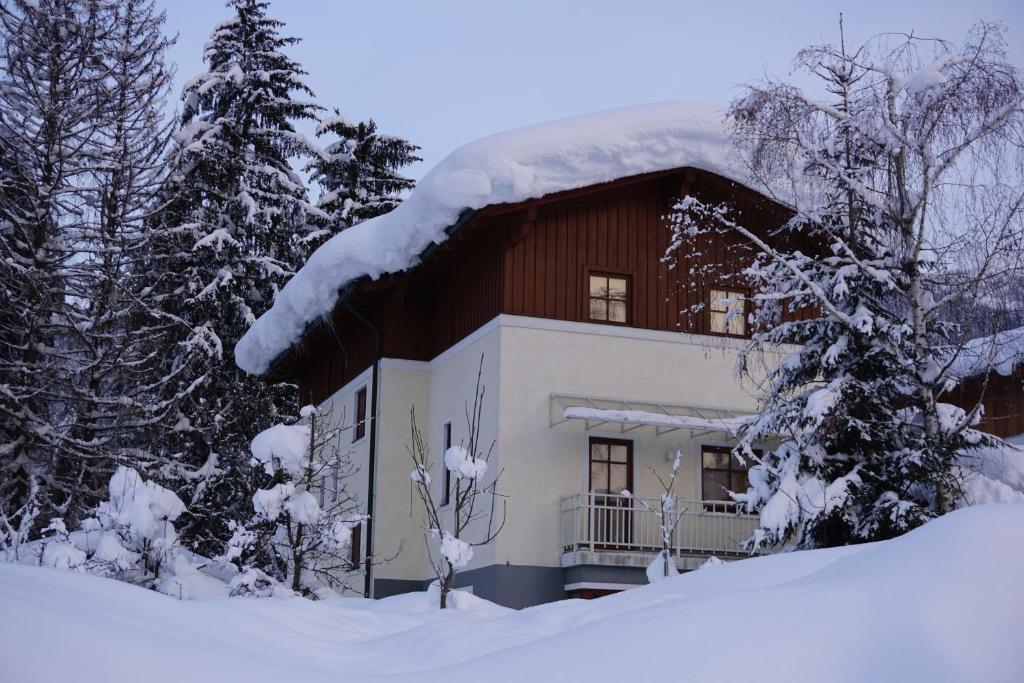 a house with a snow covered roof in the snow at Haus Johannes in Wagrain