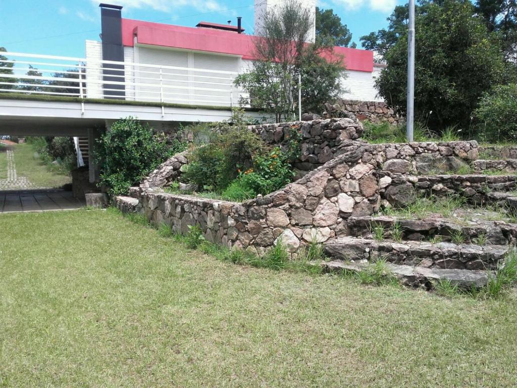 a stone retaining wall with a bridge in the background at Mi Sueño in San Antonio de Arredondo