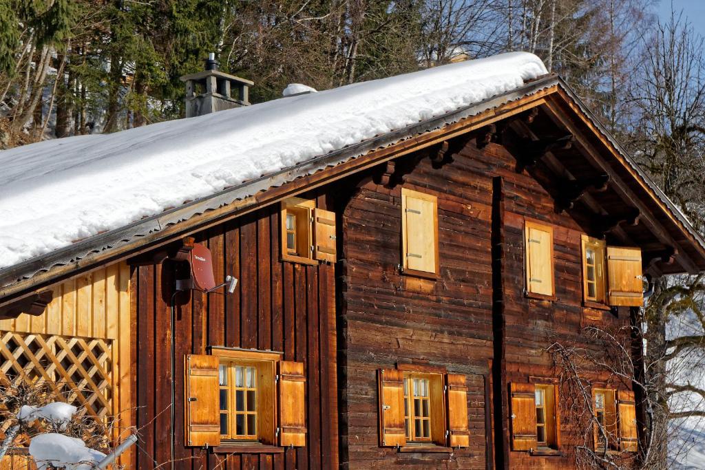 una cabaña de madera con nieve encima en Landhaus Tenne, en Bartholomäberg