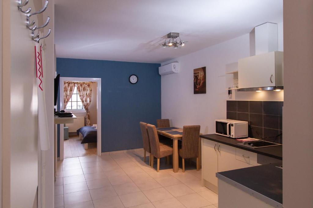 a kitchen and dining room with a table and a microwave at Ecoappart-Haz in Mosonmagyaróvár