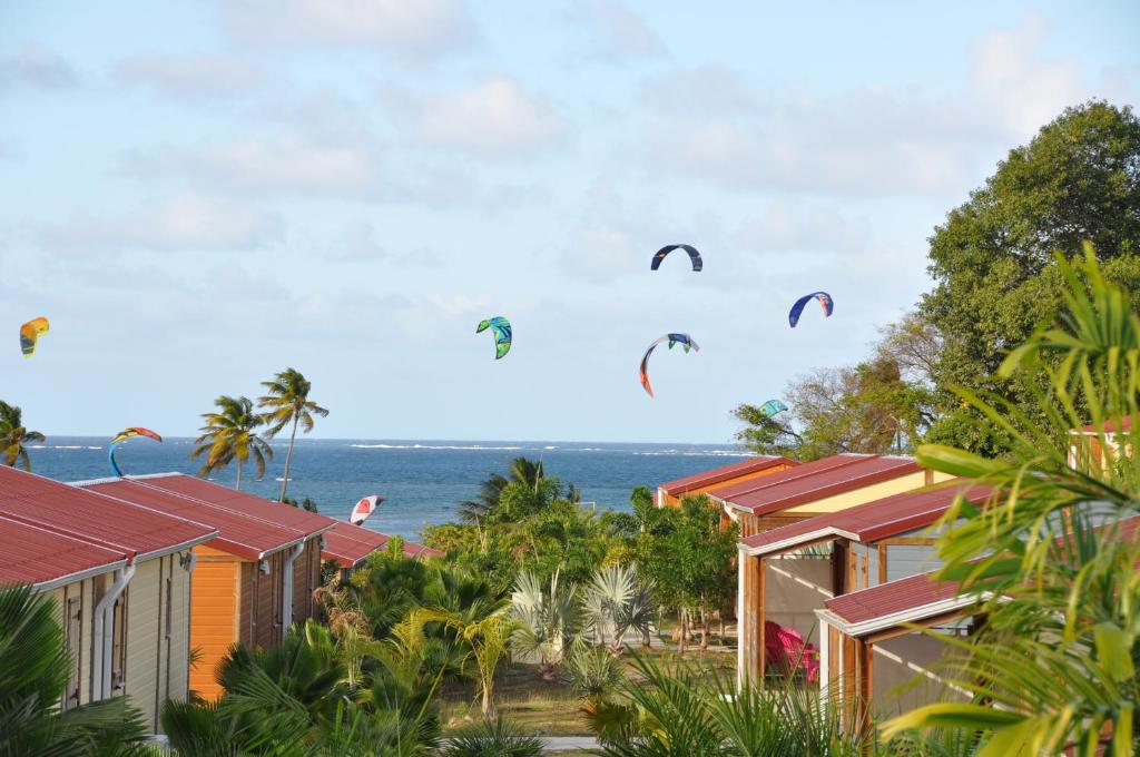 Farniente en Martinique في مدينة لو فوكلين: مجموعة من الطائرات الورقية تطير في السماء فوق المنازل