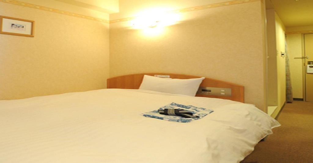 a bedroom with a white bed with a towel on it at Yonezawa - Hotel / Vacation STAY 14338 in Yonezawa