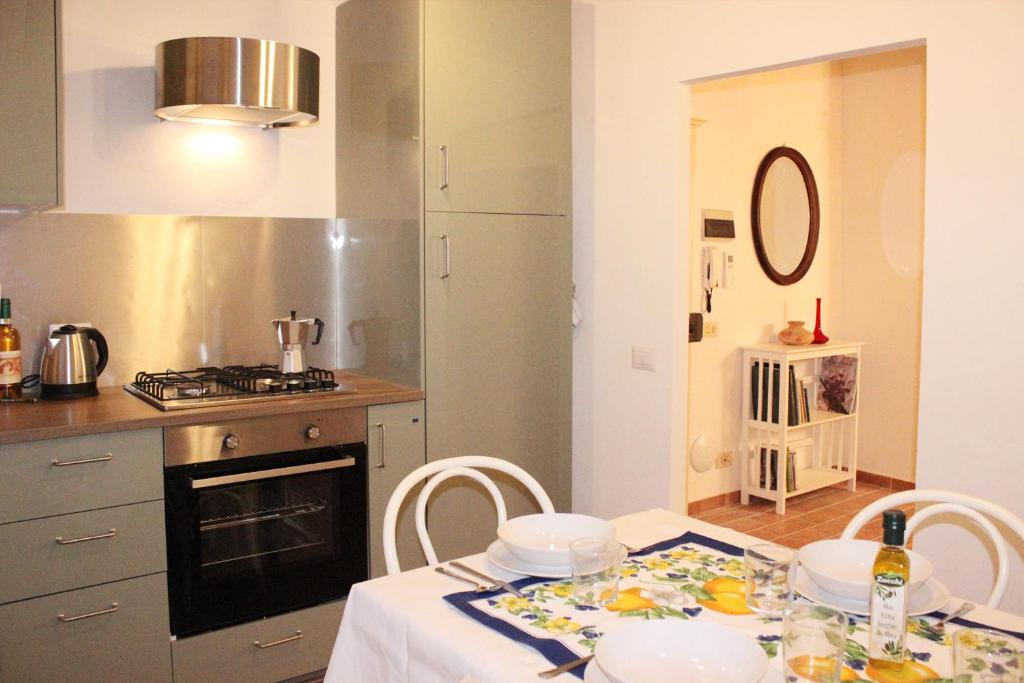 eine Küche mit einem Tisch und einem weißen Tischtuch in der Unterkunft Pancotto - Appartamento nel cuore di San Gimignano in San Gimignano