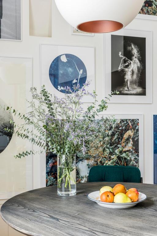 a table with a vase of flowers and a plate of fruit at Flattered to be in Porto in Porto