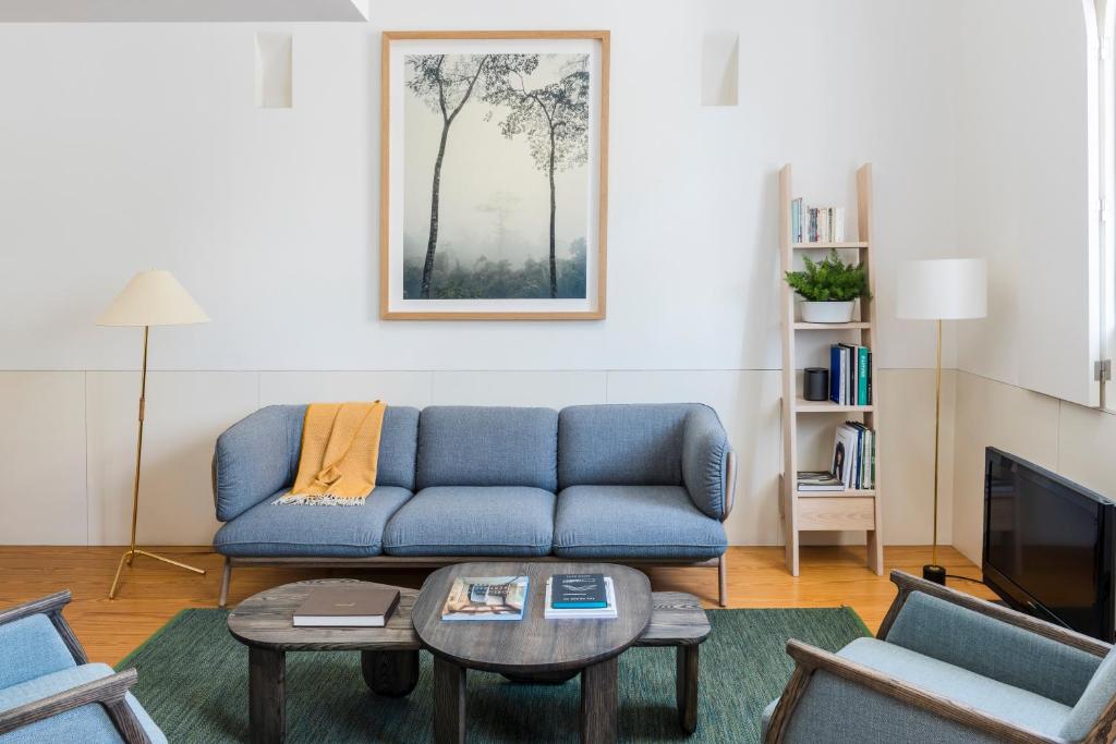 a living room with a blue couch and a table at Flattered to be in Porto in Porto