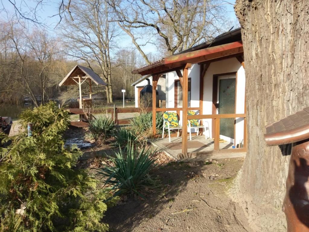 un pavillon avec une table et un banc dans un jardin dans l'établissement Spreewaldgasthaus Petkampsberg, à Schlepzig