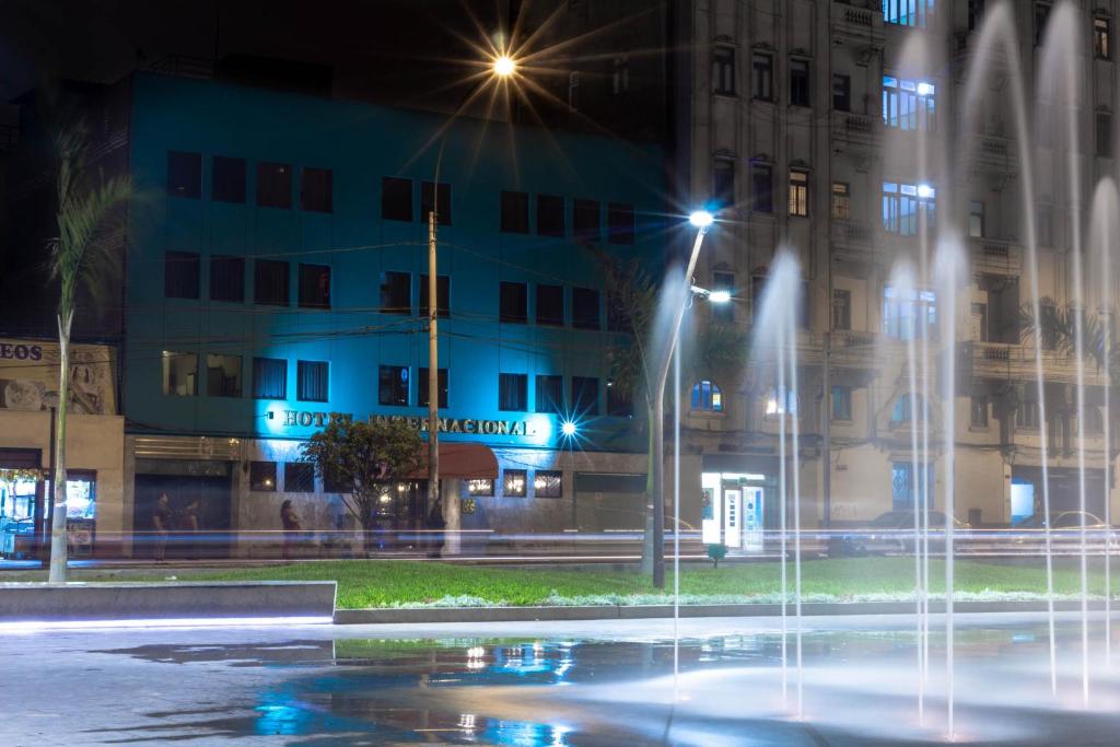 a fountain in front of a building at night at Hotel Internacional in Lima