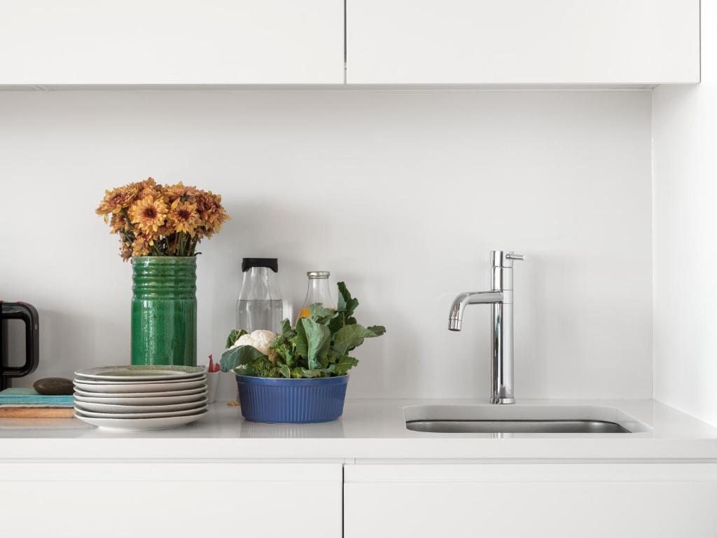 a kitchen counter with a sink and a vase with flowers at Flattered to be in Porto in Porto