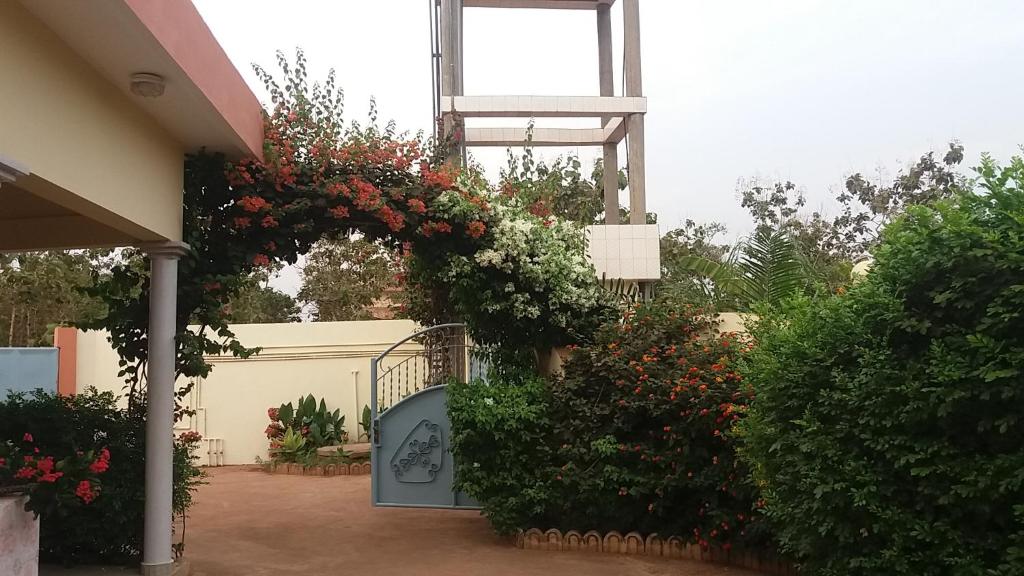 a garden with a gate with flowers on it at Chez Sabine in Abomey