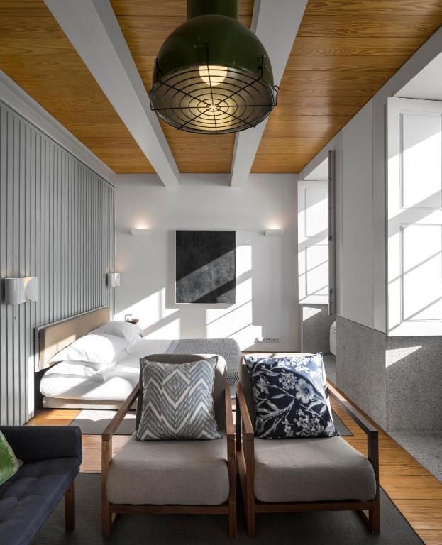 a bedroom with a bed and two chairs at Flattered to be in Porto in Porto