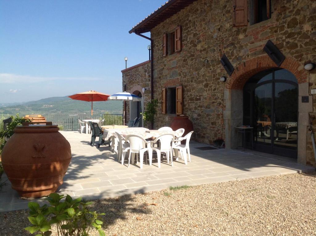 een patio met een tafel en stoelen en een gebouw bij Agriturismo Prato Barone in Rufina