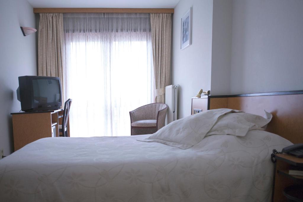 Habitación de hotel con cama y TV en Hotel Des Zouaves, en Koksijde