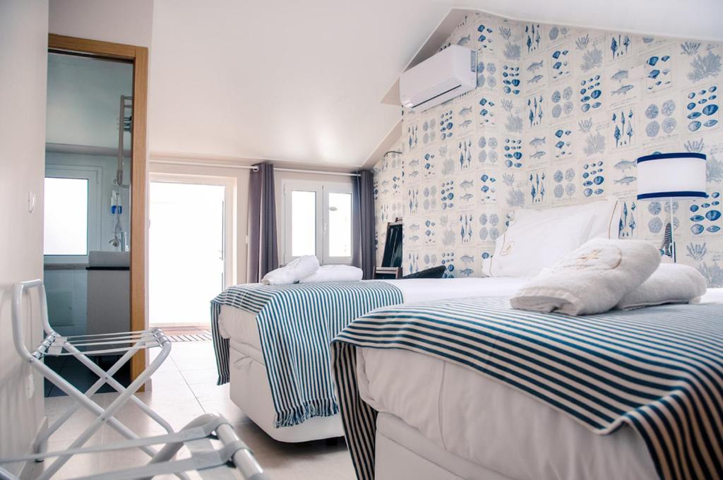 a bedroom with two beds and a blue and white wall at Portuguese Wonders in Nazaré