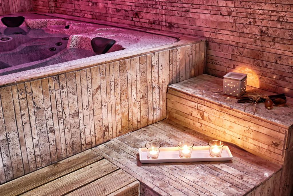 a wooden bath tub with candles and a tray of lights at Marinis Boutique Rooms in Iraklitsa
