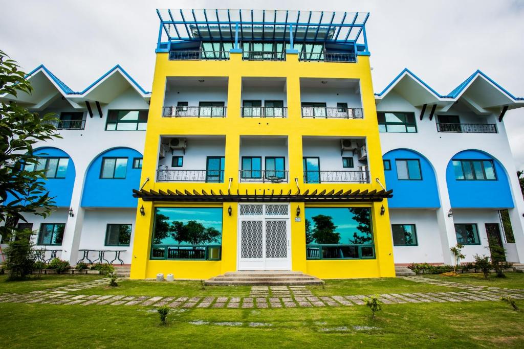 a building with a yellow and blue facade at after hill Greenhouse Resort in Wenquan