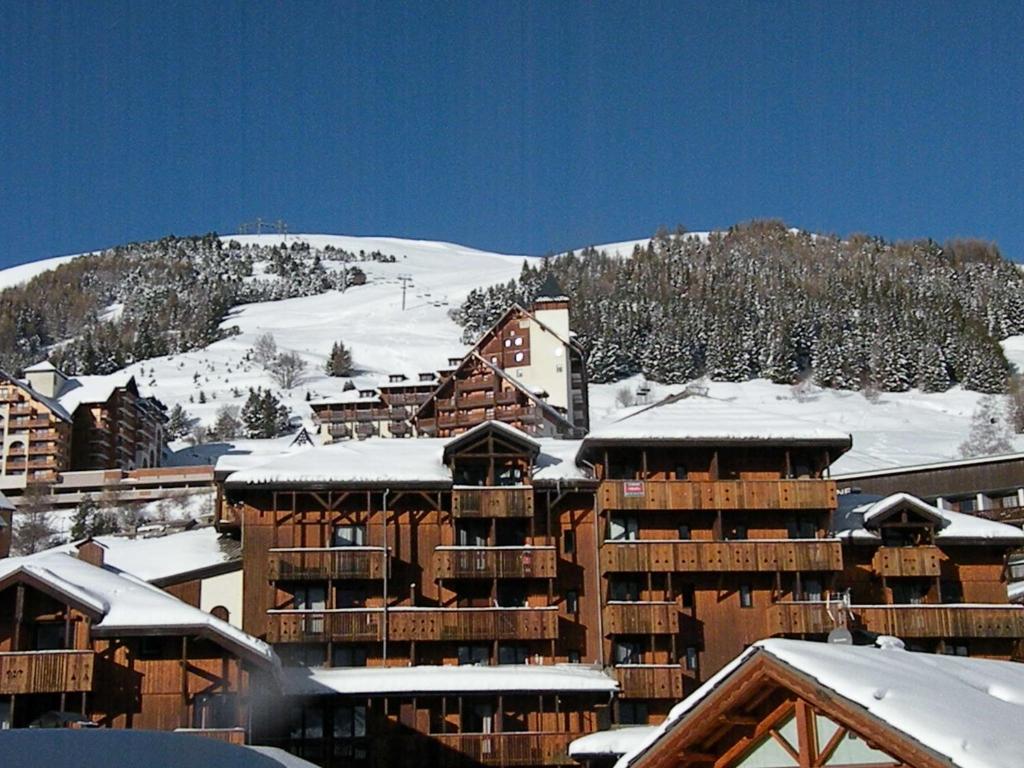 eine Skihütte mit Schnee auf den Dächern von Gebäuden in der Unterkunft Au Coeur De La Station in Les Deux Alpes