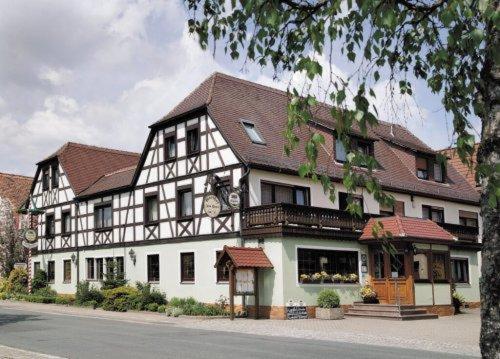 un grand bâtiment blanc avec un toit marron dans l'établissement Landgasthof - Hotel zum Stern, à Linden