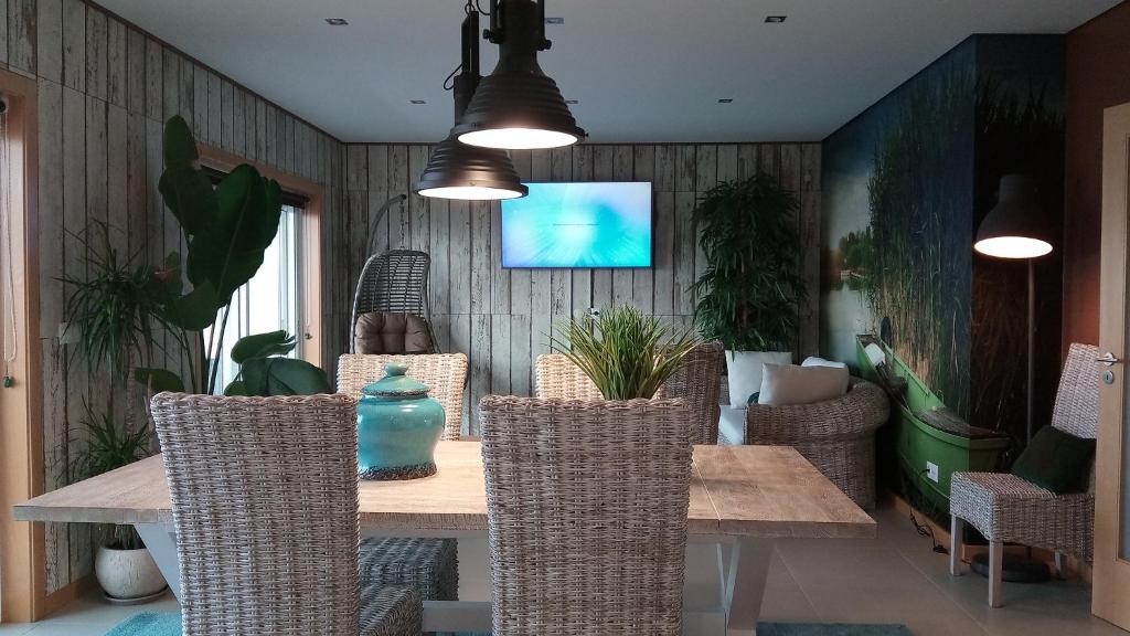 ein Esszimmer mit einem Holztisch und Stühlen in der Unterkunft Wherry Green Guest House (PRAIA DA BARRA)❤️ in Praia da Barra