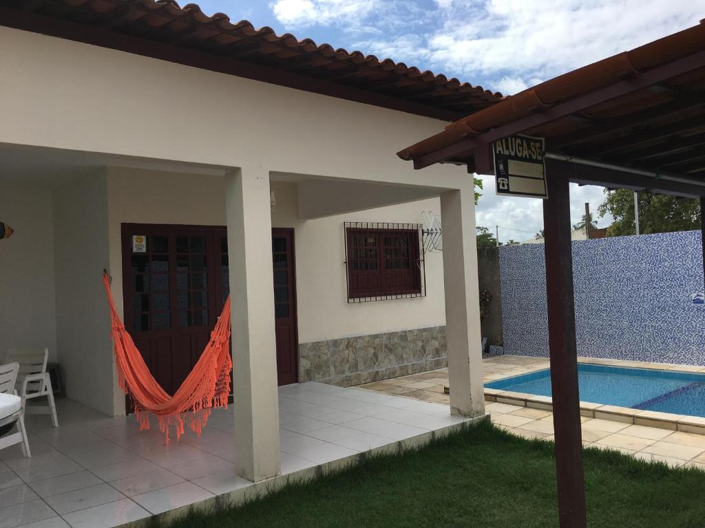 uma casa com rede ao lado de uma piscina em Casa Praia de Tamandaré PE em Tamandaré