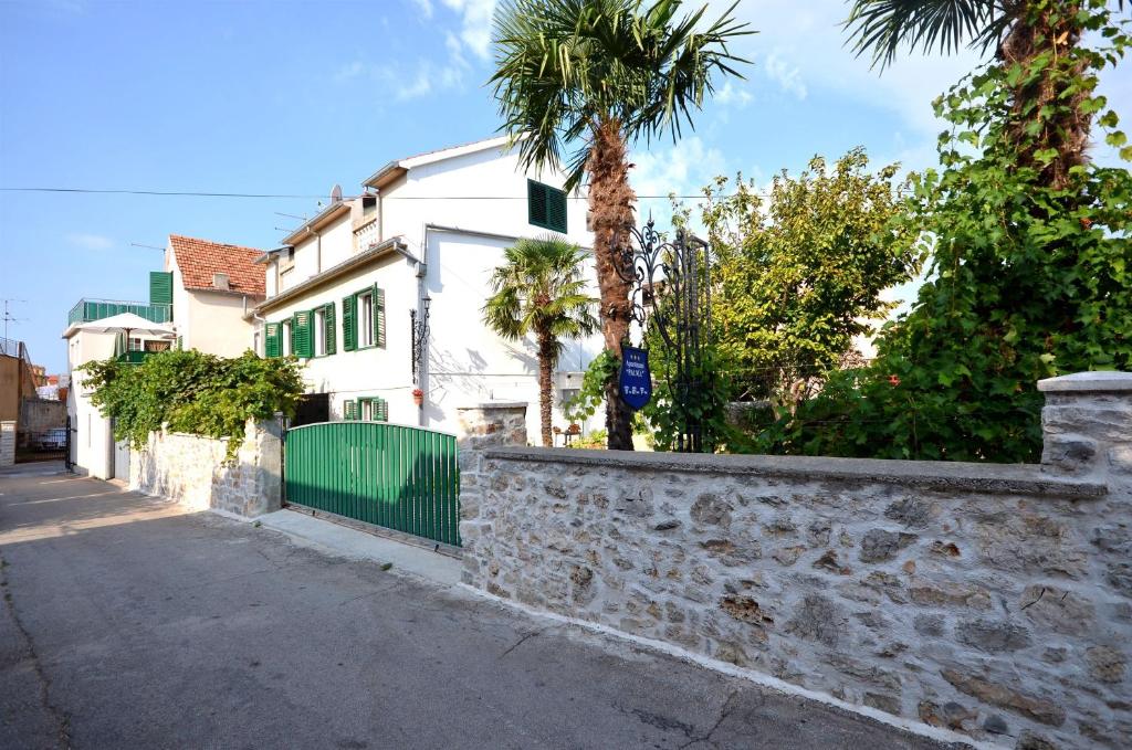 a street with palm trees and a white house at Apartments Vladimir in Vodice