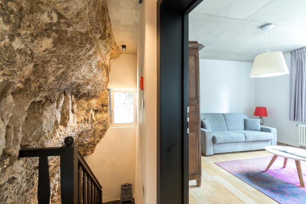 a living room with a rock wall at La Pipistrelle Hotel in Luxembourg