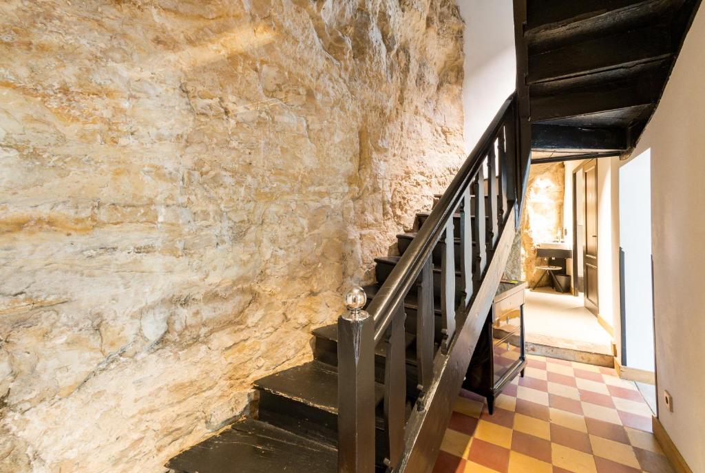 a staircase in a building with a stone wall at La Pipistrelle Hotel in Luxembourg