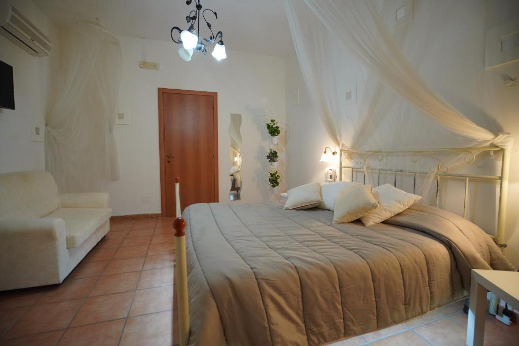 um quarto com uma cama grande e uma cadeira em Hotel Stefany em Lago Patria