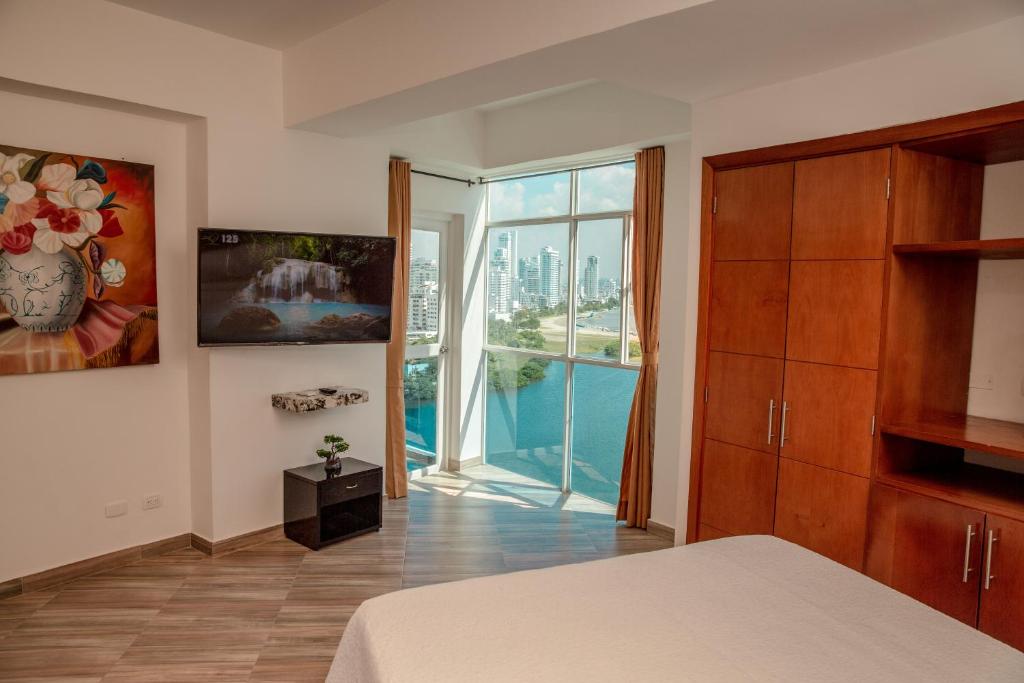 1 dormitorio con cama y ventana grande en Poseidon Lake Apartments, en Cartagena de Indias