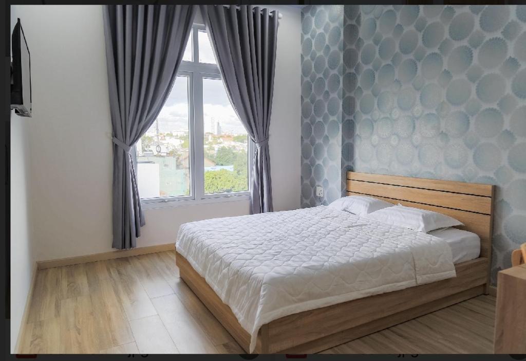 Un dormitorio con una cama grande y una ventana en Nam Anh Hotel, en Buon Ma Thuot