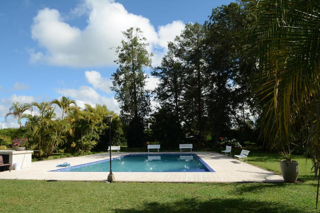 una piscina con 2 sillas en un patio en Casa Finca Corales Llano Grande 1, en Rionegro