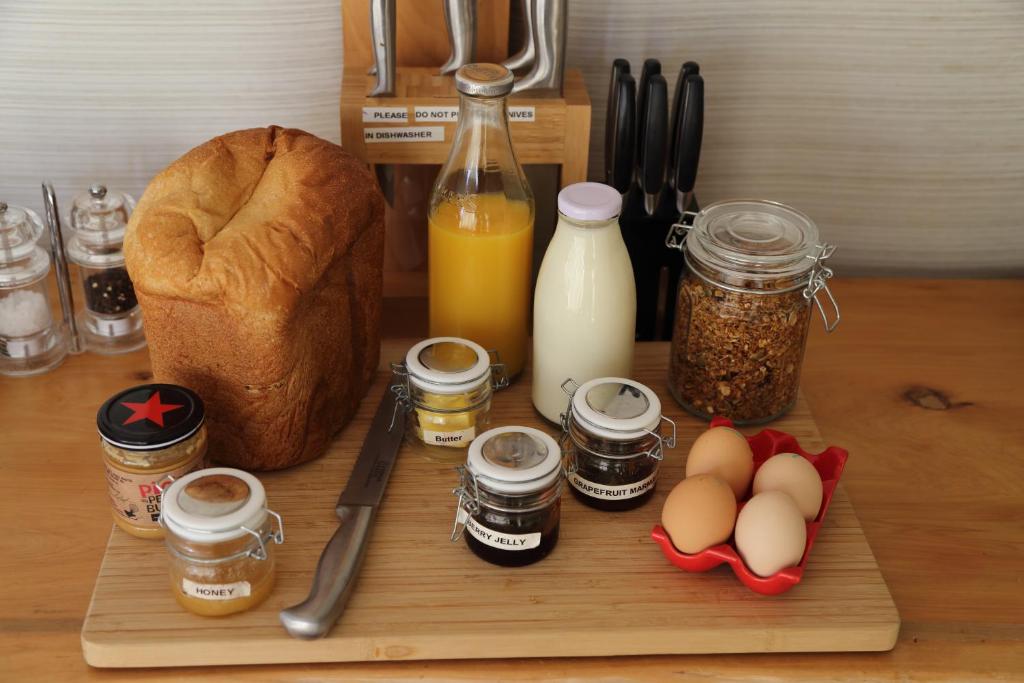 a cutting board with eggs and bread and bottles of milk at The Sanctuary at The Havens Motueka River Valley in Tasman