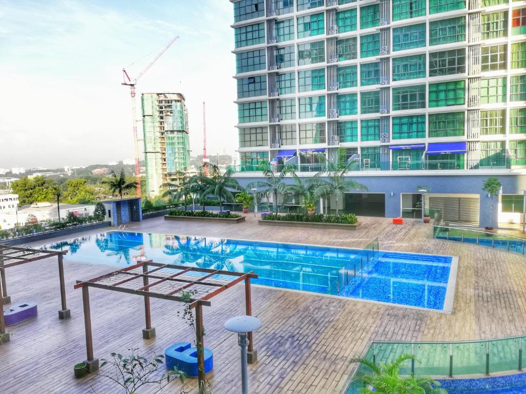 una piscina di fronte a un edificio alto di Guesthouse at Shah Alam a Shah Alam