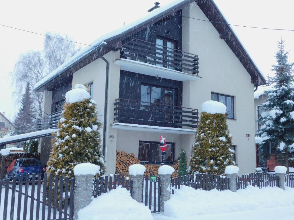 ein Haus mit schneebedeckten Weihnachtsbäumen davor in der Unterkunft Pod Dubom in Liptovský Mikuláš