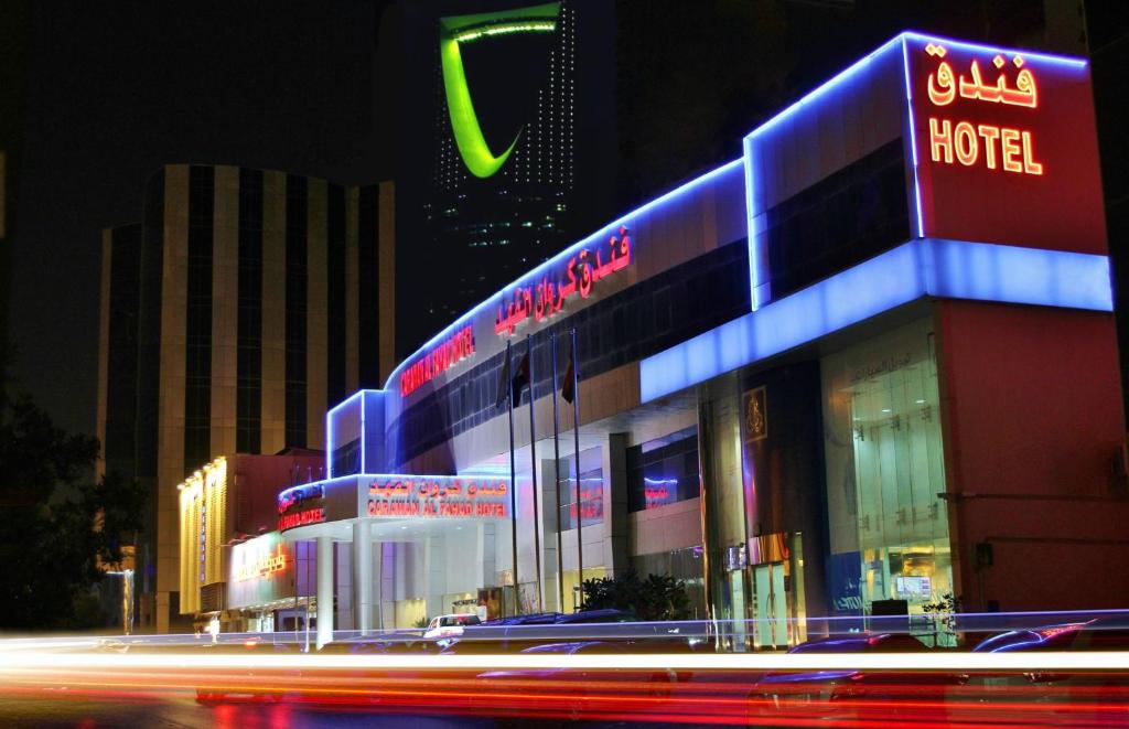 a building with a neon sign on the side of it at Carawan Al Fahad Hotel in Riyadh