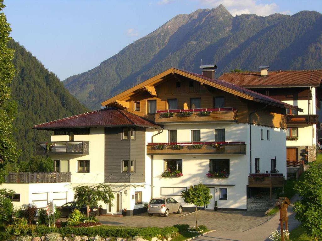 ein großes weißes Gebäude mit Bergen im Hintergrund in der Unterkunft Edelweiss Apartments in Schladming