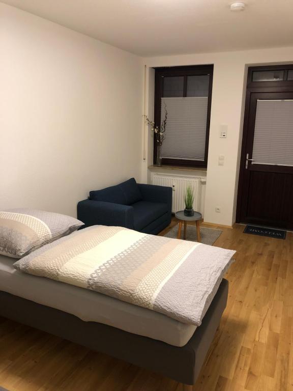 una camera con un letto e un divano blu di Apartment am Schloßplatz Erlangen a Erlangen