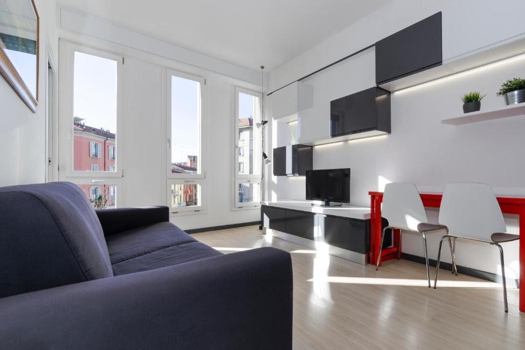 ein Wohnzimmer mit einem Sofa, einem Tisch und Stühlen in der Unterkunft Casa da Suite Idea in Mailand