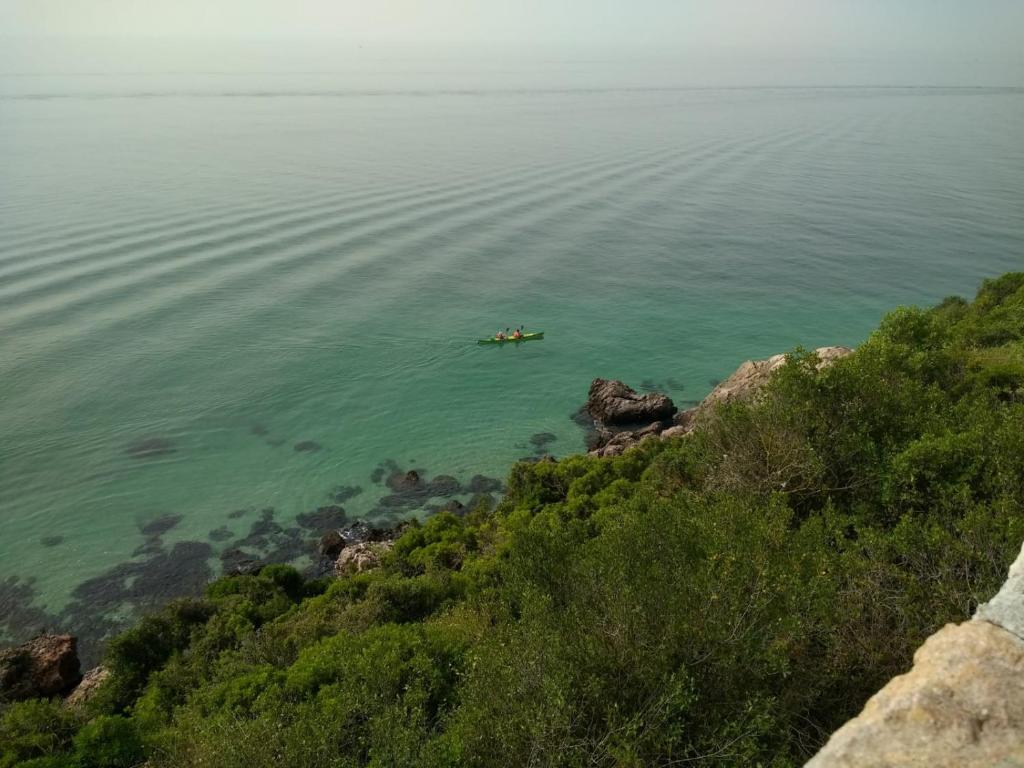 a boat in the water next to a mountain at Casa dos Avós in Villa Nogueira