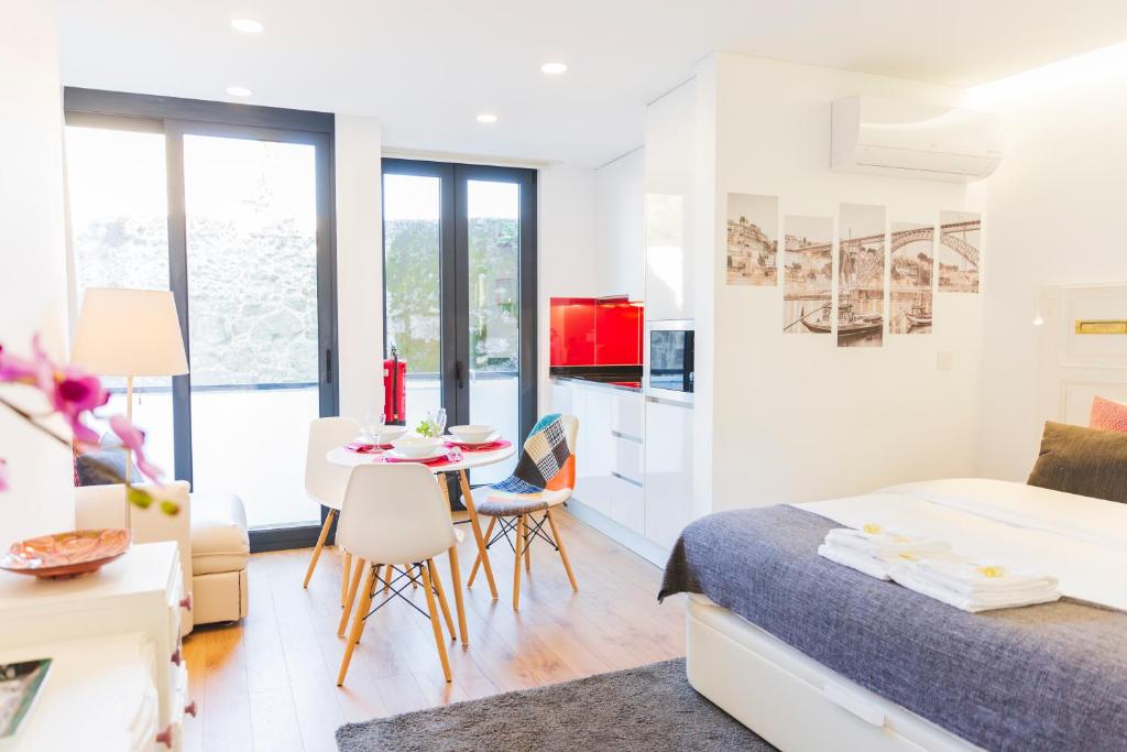 ポルトにあるAPOSENTUS - Your Home at Pinheiro's Studioのベッドルーム1室(ベッド1台、テーブル、椅子付)