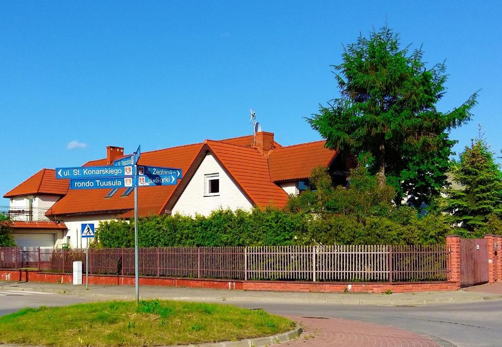 a house with an orange roof and a street sign at U pani Ani Augustów in Augustów