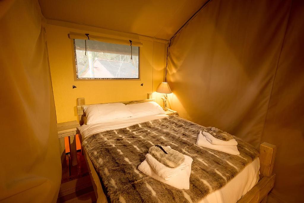 a bedroom with a bed with towels on it at Sweeney Farm Glamping in Oswestry