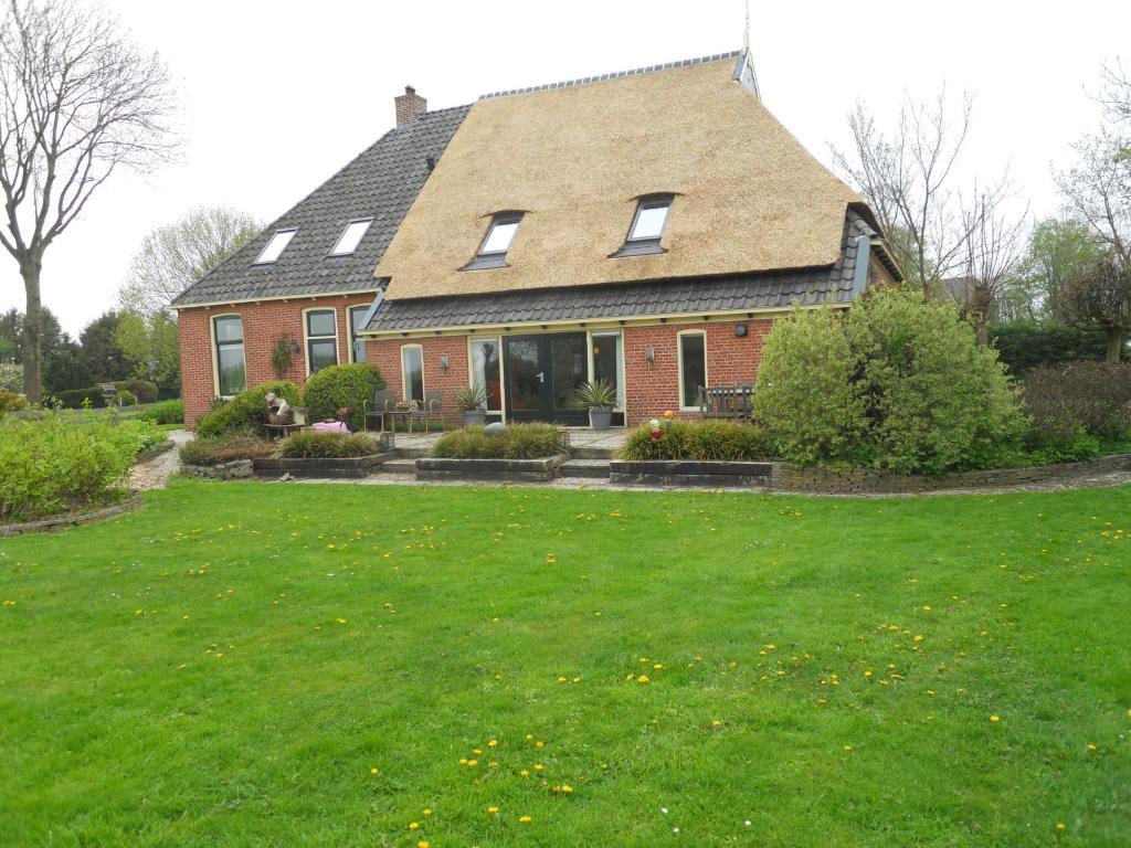 una casa con un césped verde delante de ella en Rêst en Romte, en Birdaard