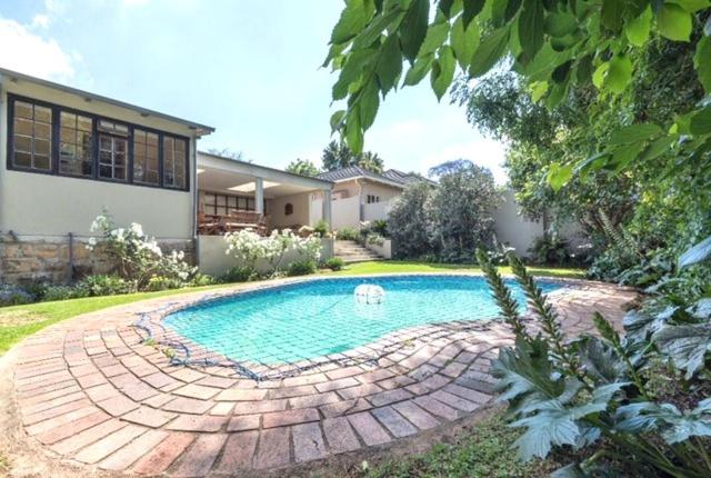 a swimming pool in a yard next to a house at Forest Haven in Johannesburg