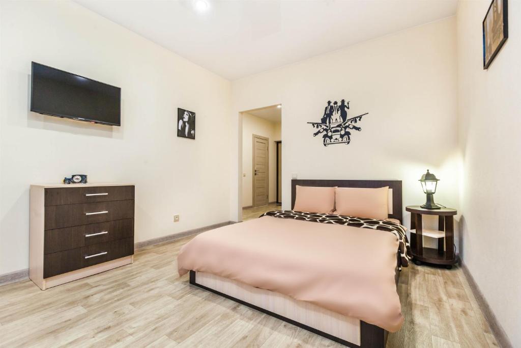 a bedroom with a large bed and a flat screen tv at Апартаменты в новом жилом комплексе Кристалл in Tyumen