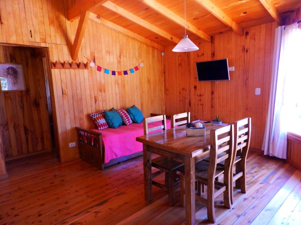 - une salle à manger avec une table et un lit dans l'établissement Casita de Madera, à San Carlos de Bariloche