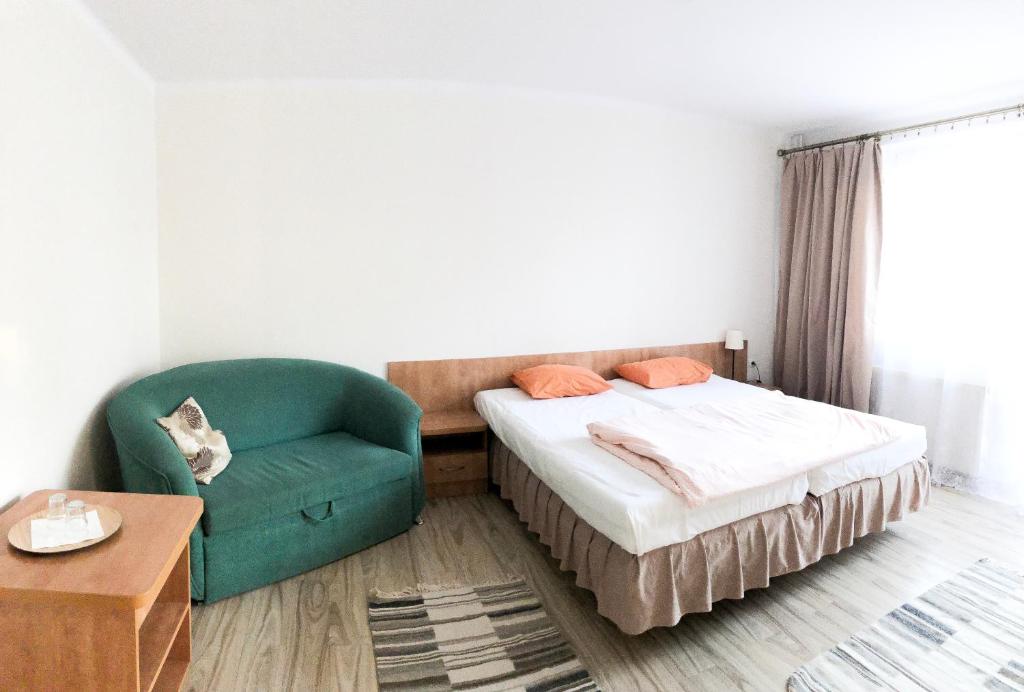 1 dormitorio pequeño con 1 cama y 1 silla en Gościniec Paradise, en Mierzęcice