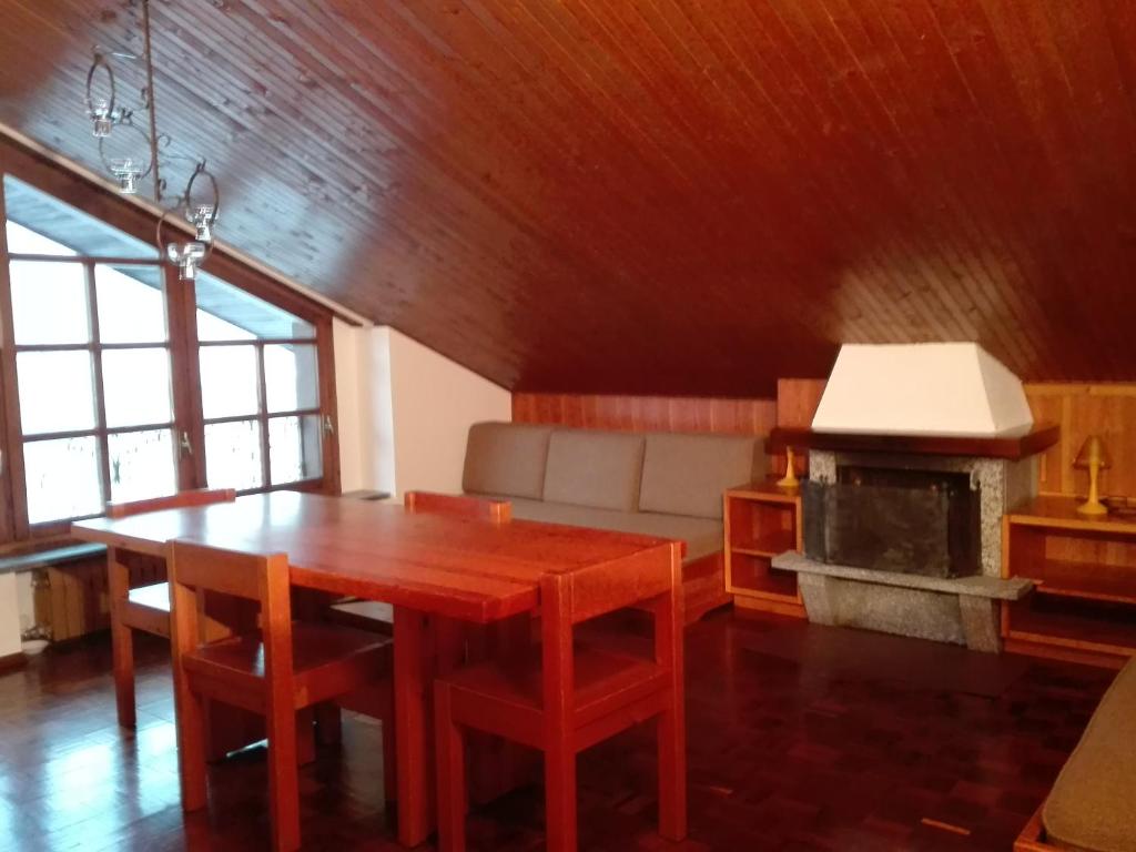 a living room with a wooden table and a fireplace at Mansarda condominio Royal in Valtournenche