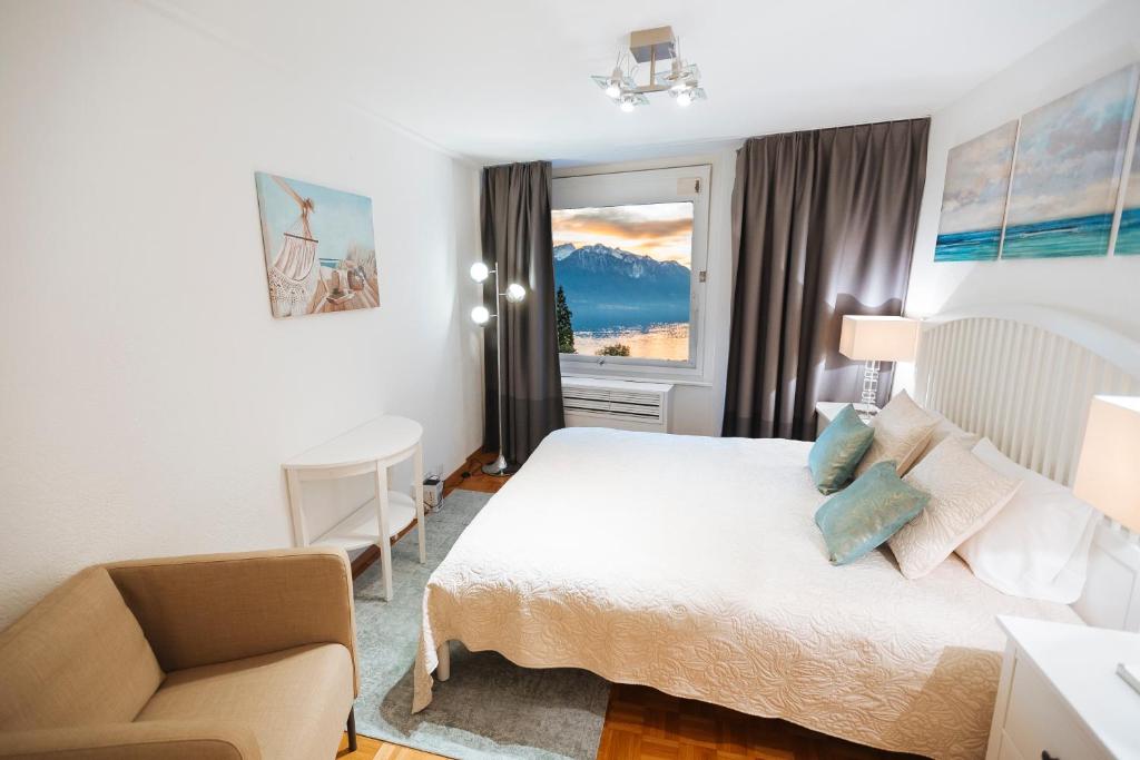 una camera con un letto e una sedia e una finestra di ☆ Central Apartment with Montreux View ☆ a Montreux