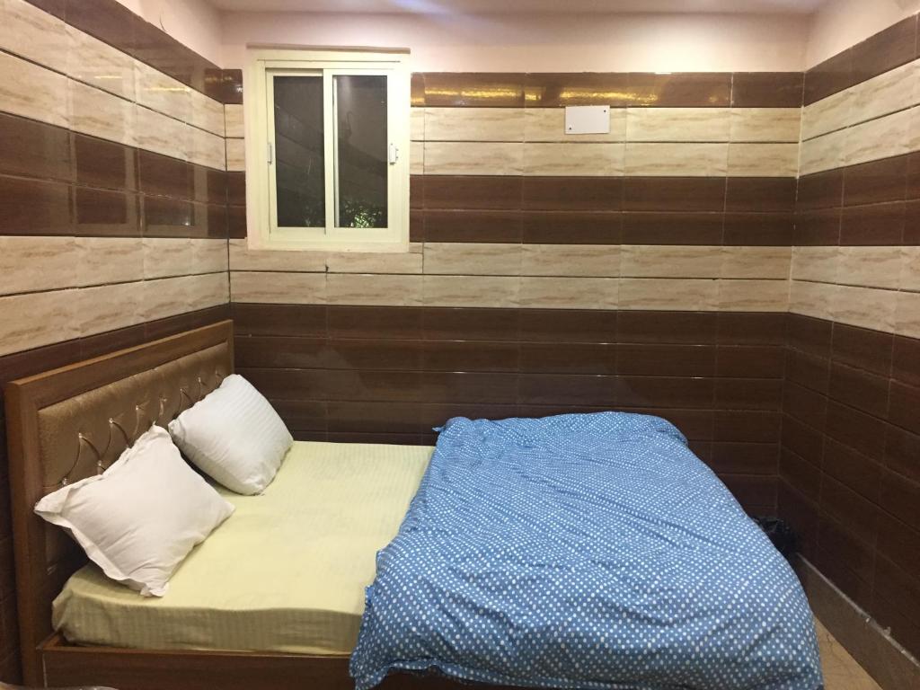 Cama pequeña en habitación con ventana en Royal Residency, en Nueva Delhi