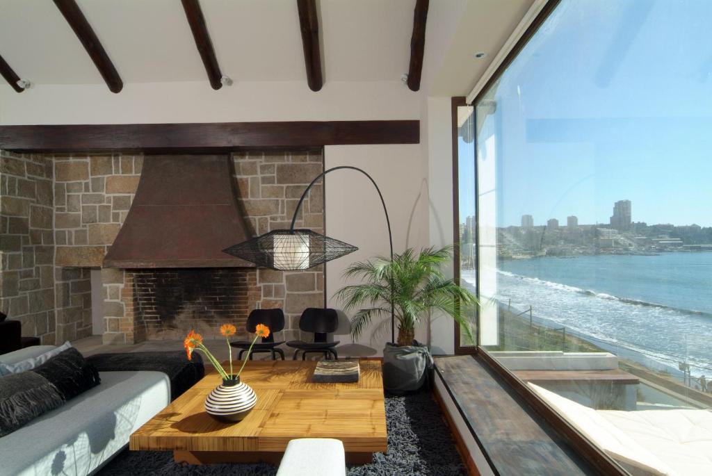 a living room with a couch and a fireplace at Hotel Boutique Casadoca in Concón